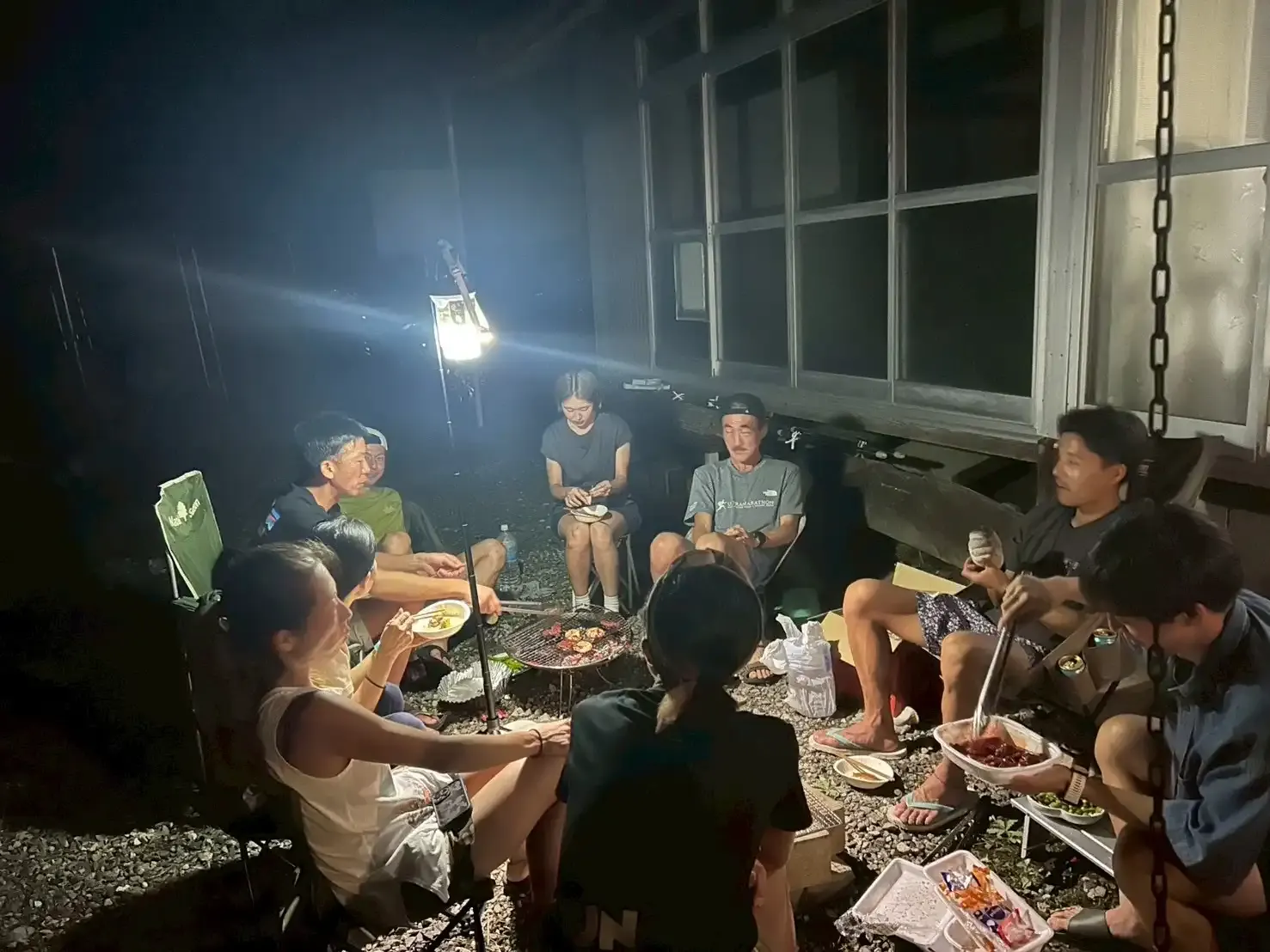 夜の庭でバーベキューを楽しむ参加者